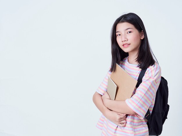 Girl student holding books with backpacks.