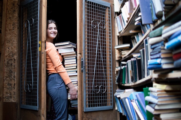 Foto la studentessa tiene una grande pila di libri