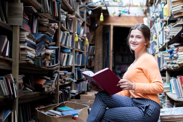 Girl student reads a book in the old library a woman is looking for information in the archives