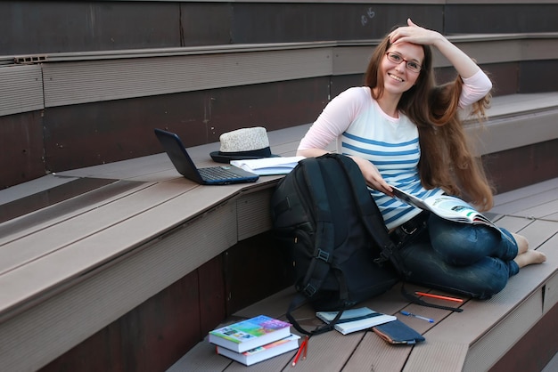 女子学生は屋外で宿題を勉強します