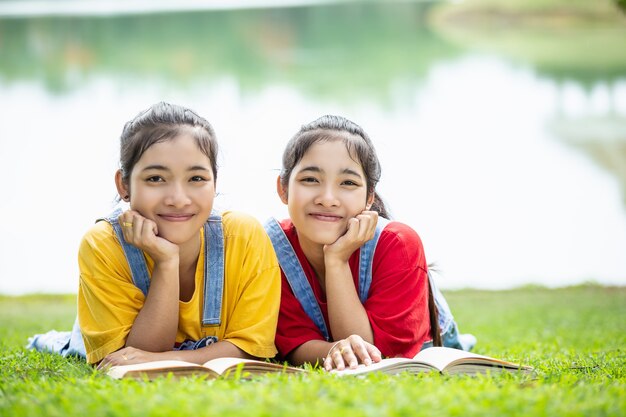 公園の本を読んでいる少女や学生