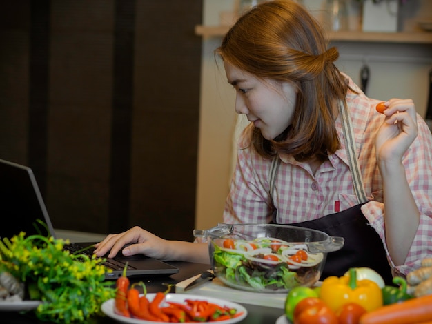 Девушка изучает, как делать чистую пищу, используя интернет