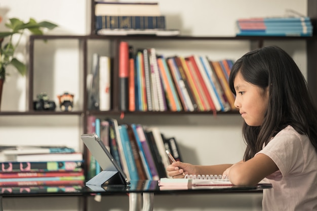 Girl studying online with tablet at home