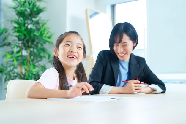 勉強する女の子とサポートするスーツを着た女性