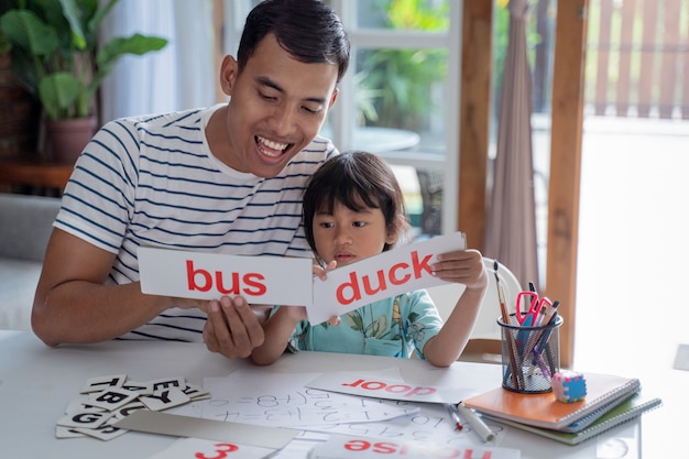 Girl studying words with father at home