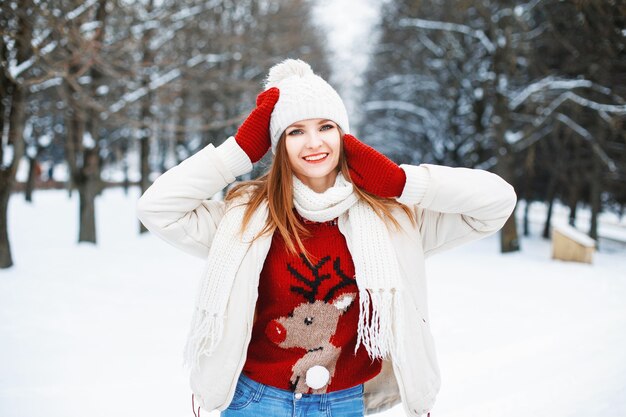 Girl in stylish winter clothes resting in a park