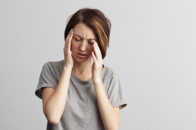 Girl suffers from terrible headaches and compresses the head with fingers