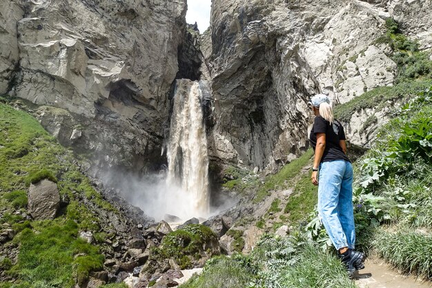 A girl at the Sultansu waterfall surrounded by the Caucasus Mountains near Elbrus Jilysu Russia