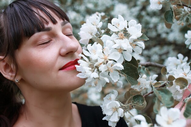 Girl in a summer garden sunny day blossom tree