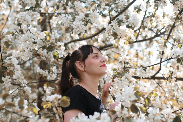 Ragazza in un giardino estivo in una giornata di sole albero in fiore