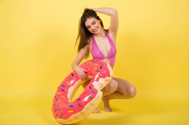 Девушка в летних купальниках купальный костюм с надувным матрасом пончик лило.