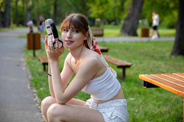 A girl in a summer white outfit relaxes in a park