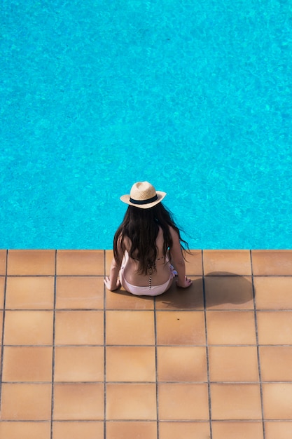  girl sunbathing peacefully in the pool of her house.