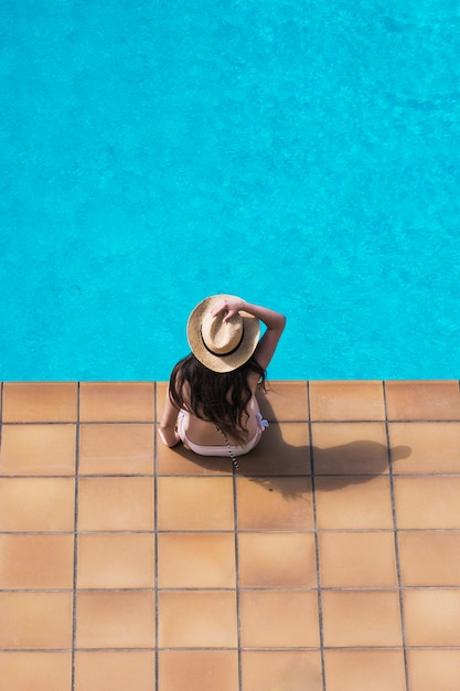 彼女の家のプールで平和的に日光浴の女の子。