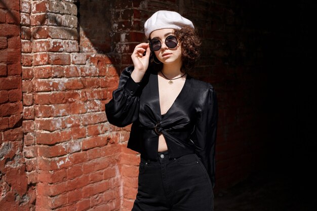 Girl in sunglasses and beret in the city