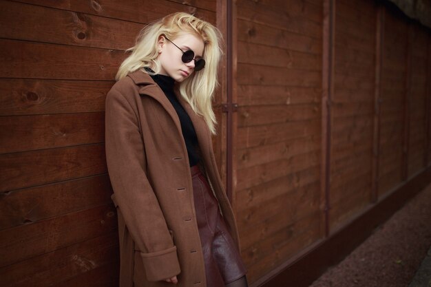 Photo girl in sunglasses on the wooden background.