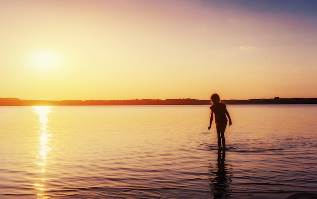 湖で夕暮れ時の女の子