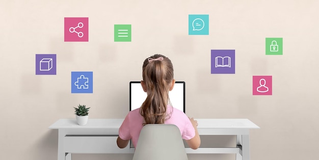 Girl surfs the internet on a laptop computer The concept of using a computer for communication with friends learning and safety on the Internet with hovering icons overhead