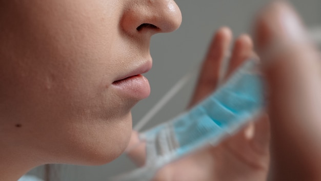 Photo girl surgeon doctor puts surgical mask on her face