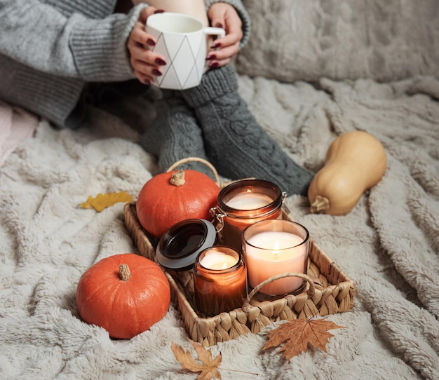 A girl in a sweater and knitted socks sits on a blanket