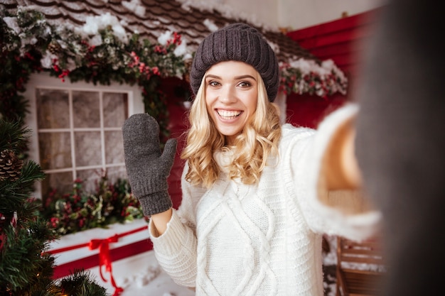 Girl in sweater makes selfie near the house