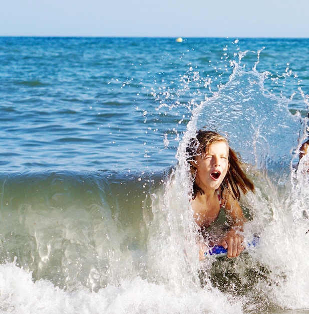 Foto ragazza che nuota in mare contro il cielo