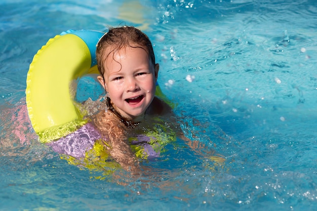 Girl swimming in the summer pool