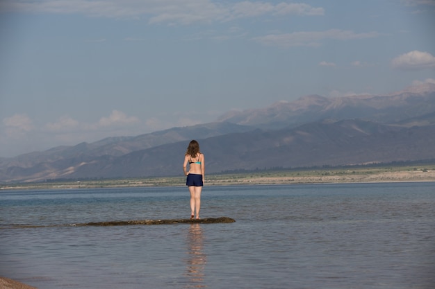 Girl in a swimsuit on a mountain lake