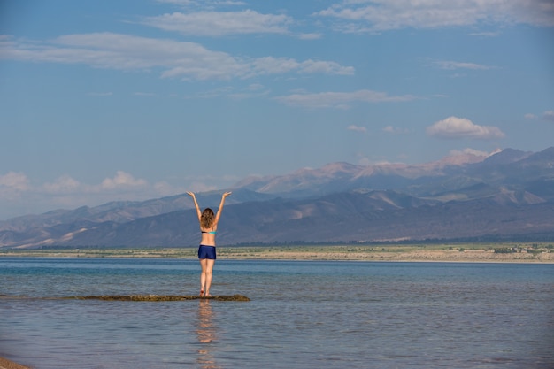 Girl in a swimsuit on a mountain lake