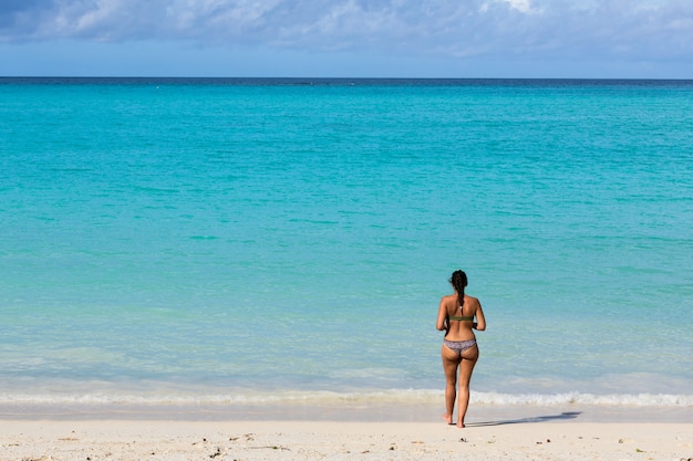 girl in a swimsuit standing on the seashore