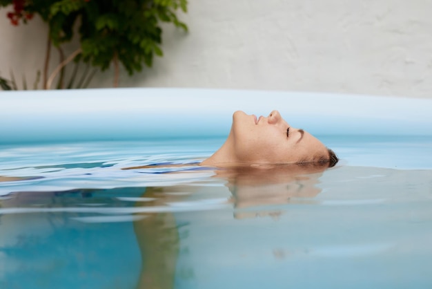 девушка в купальнике плавает в бассейне в жаркое лето концепция жаркого лета