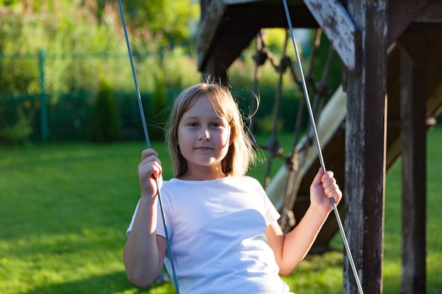 Girl swings on a swing in the yard