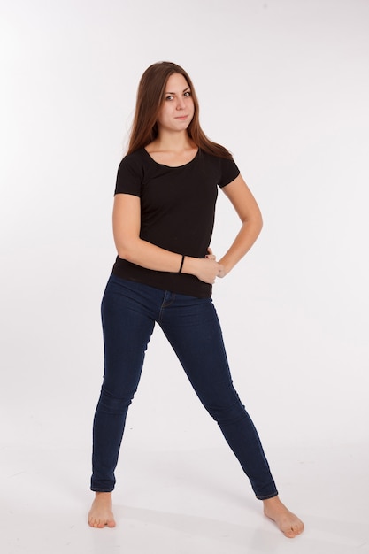 Ragazza in t-shirt e jeans su sfondo bianco