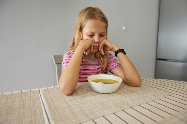 The girl at the table does not want to eat