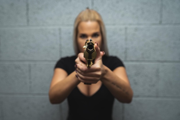 Foto una ragazza prende la mira con una pistola dorata desert eagle foto soft focus