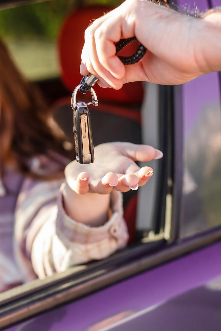 女の子は車のキーを取ります車の販売とレンタル車のディーラー