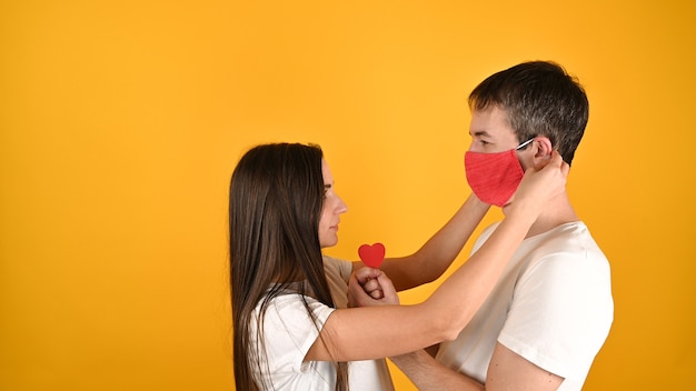 The girl takes off the guy\'s mask on yellow