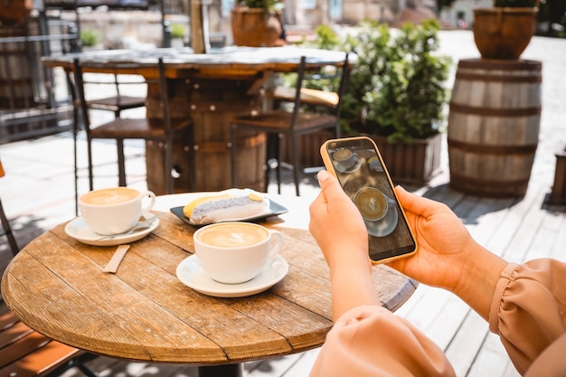 女の子がカフェで食べ物の写真を撮る