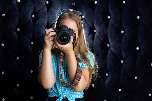 A girl takes photos with a SLR camera in the Studio