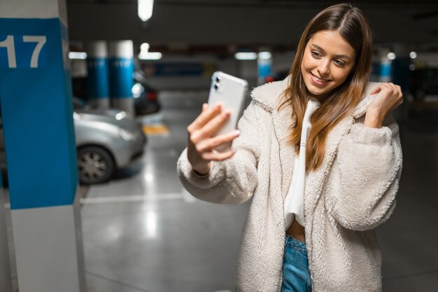 Girl takes selfie in the underground parking.