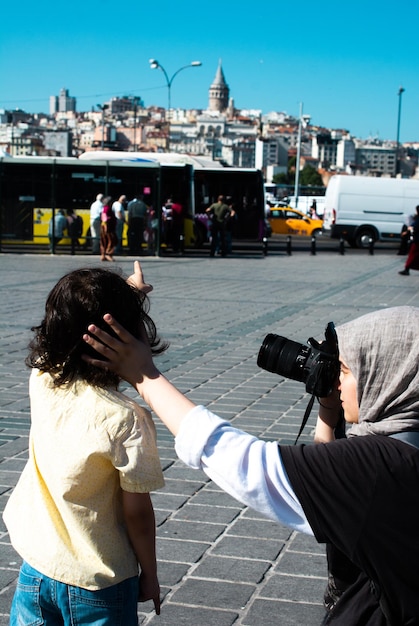 Girl taking the photo of boy with istanbul panorama behind