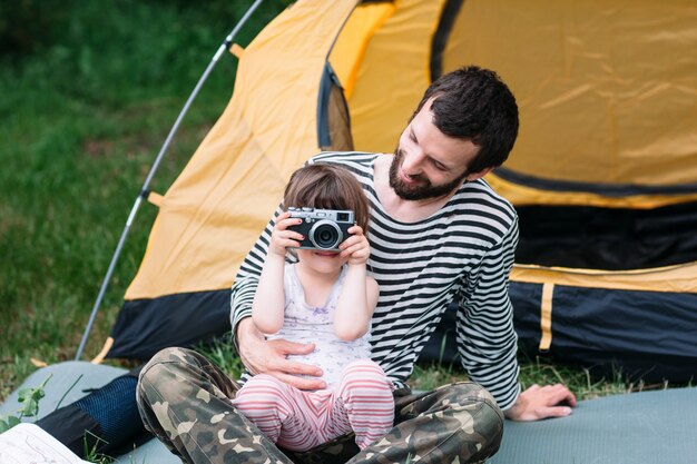 Девушка фотографируется с отцом в поездке на природу