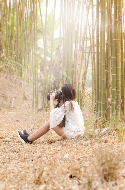 девушка фотографирует в бамбуковом лесу