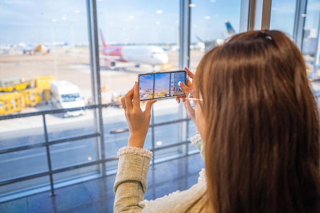 Girl taking picture thru the window on the moving walkway