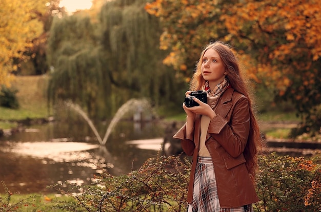 girl taking pictures in autumn park