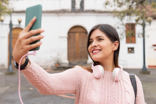 Girl taking a selfie with her green mobile