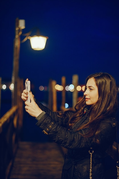 Девушка разговаривает по телефону и фотографирует в Венеции Италия