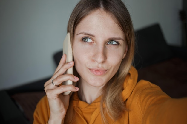 A girl talks on the phone and looks away