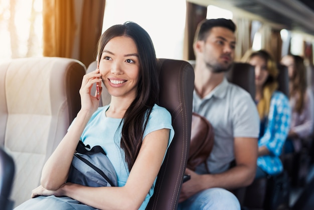 Girl Talks on Phone Passengers Travel by Tour Bus.