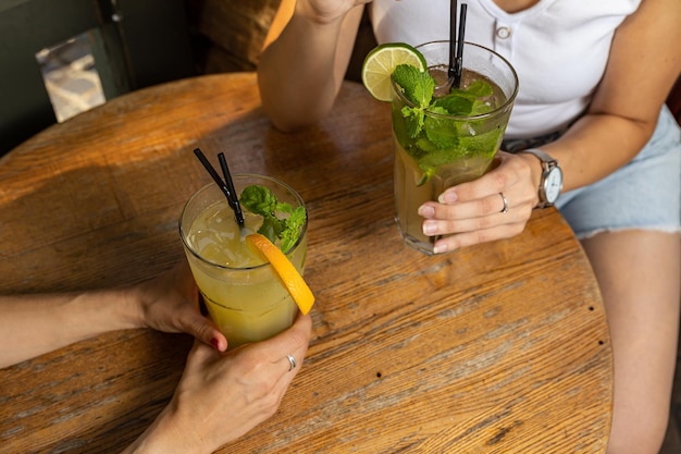 The girl tastes a cocktail at the restaurant bar